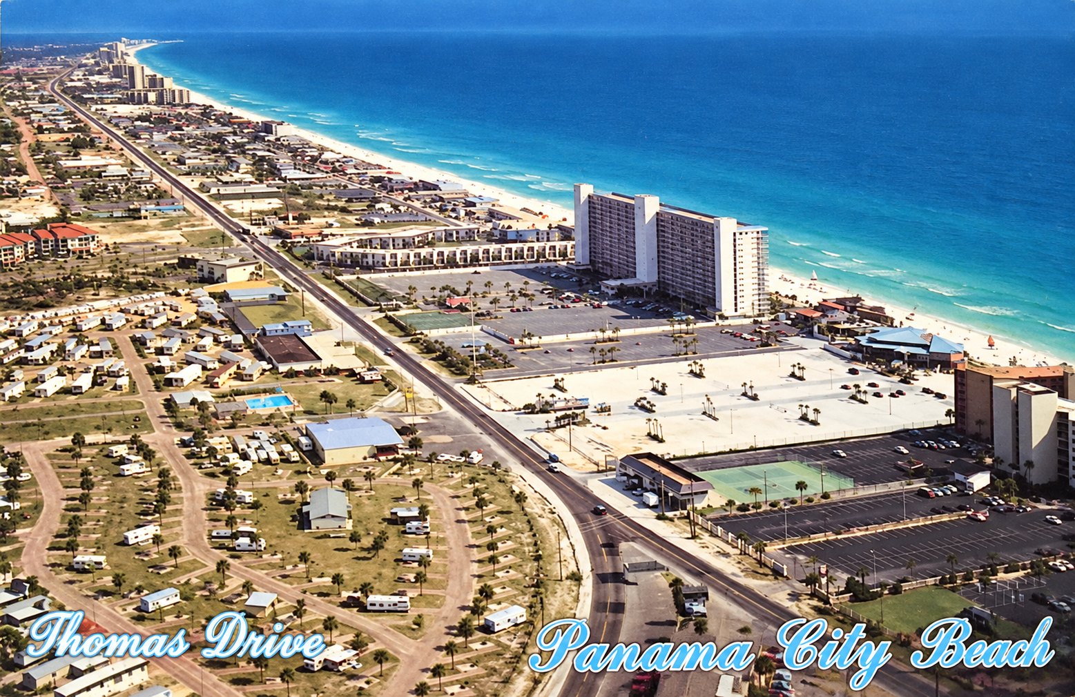 A vintage aerial postcard lettered “Thomas Drive” and “Panama City Beach”: the Summit stands beside the beach and the Gulf at the center, with Thomas Drive running past it.
